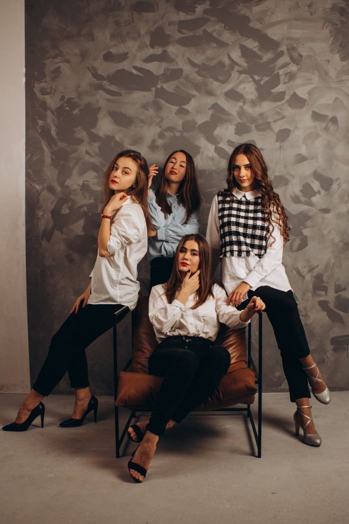 Crafting Captivating Headlines: Your awesome post title goes here Four fashionable young women posing in a sophisticated indoor setting.