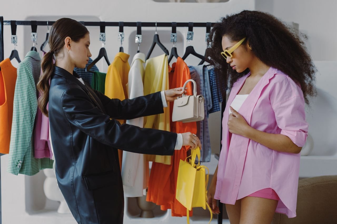 Services Two women shopping and exploring trendy fashion in a boutique setting.
